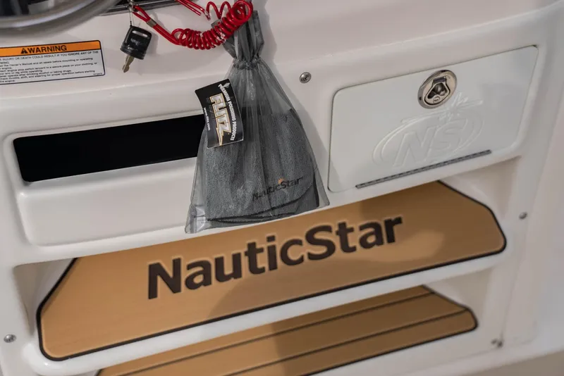 Slide: The Image of NauticStar 2102 Legacy 2022 boat interior with branded mat and storage compartment. - 9