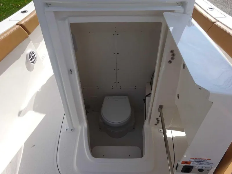 Slide: The Image of 2024 Robalo R230 boat interior with built-in marine toilet. - 10