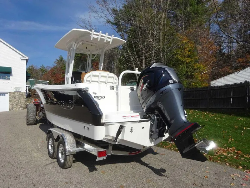 Slide: The Image of 2024 Robalo R230 boat on trailer, parked outdoors, with outboard motor. - 4