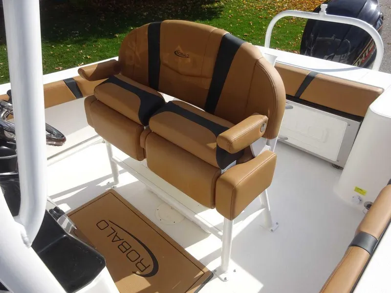 Slide: The Image of 2024 Robalo R230 boat interior with tan seating and branded mat. - 6