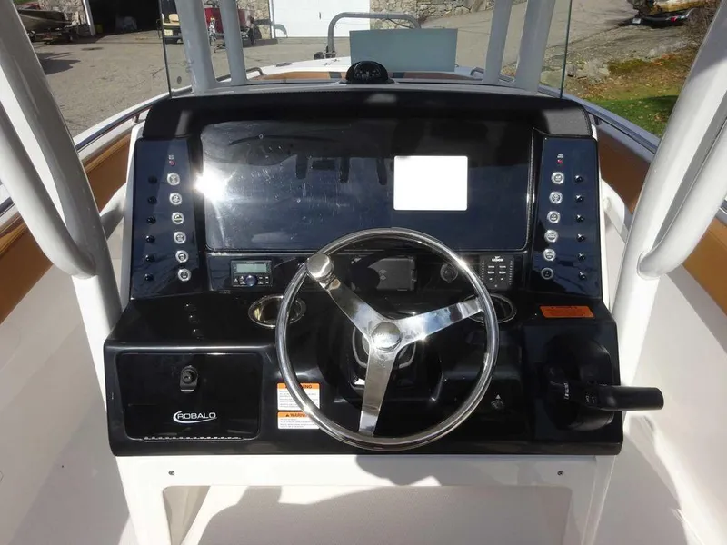 Slide: The Image of 2024 Robalo R230 boat dashboard with steering wheel and control panel. - 7