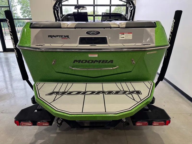 Slide: The Image of Green 2021 Moomba Max boat displayed indoors. - 8