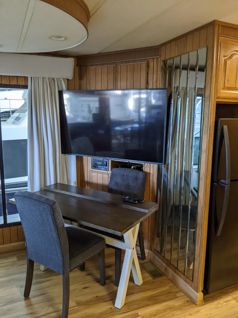 Slide: The Image of 2001 Monticello River Yacht interior with TV, desk, and chair setup. - 10