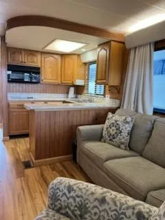 Slide: The Image of Interior of a 2001 Monticello River Yacht with cozy seating and wooden kitchen cabinetry. - 15