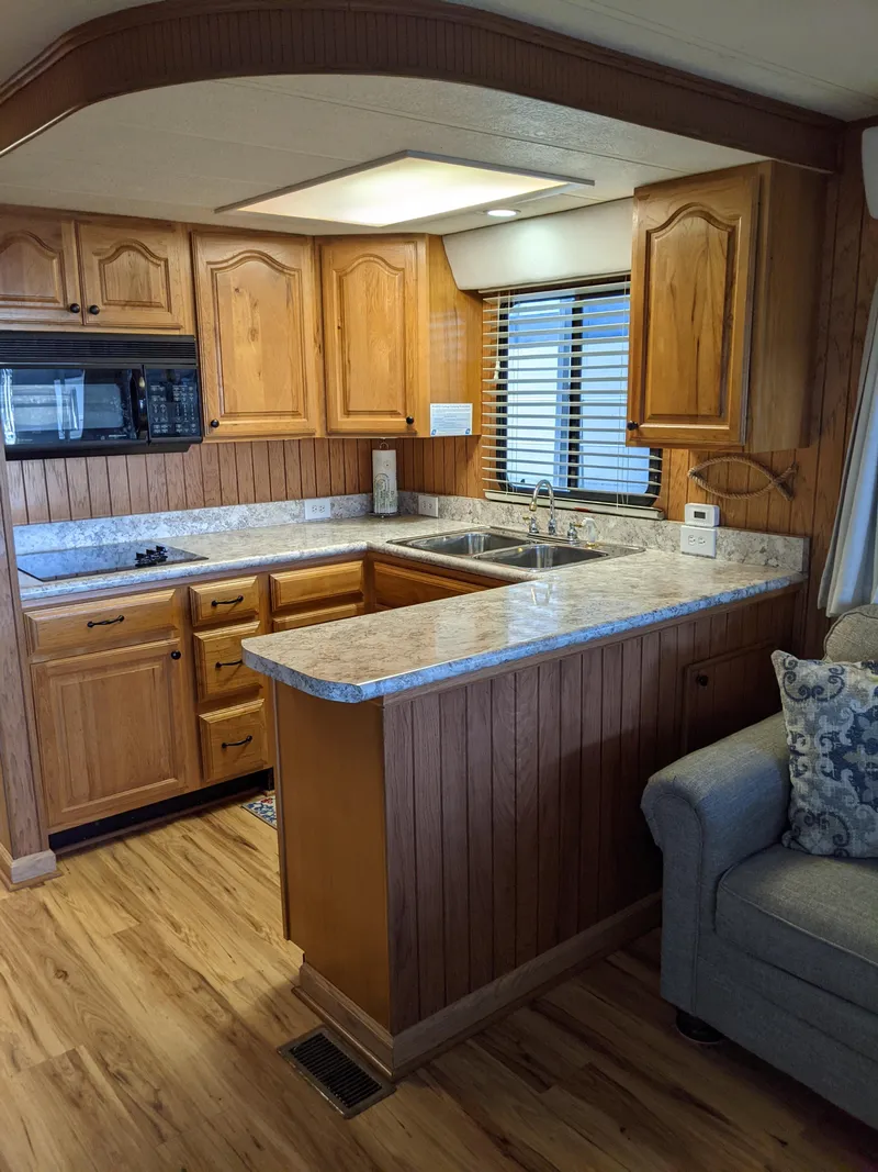 Slide: The Image of 2001 Monticello River Yacht kitchen with wooden cabinets and marble countertops. - 16