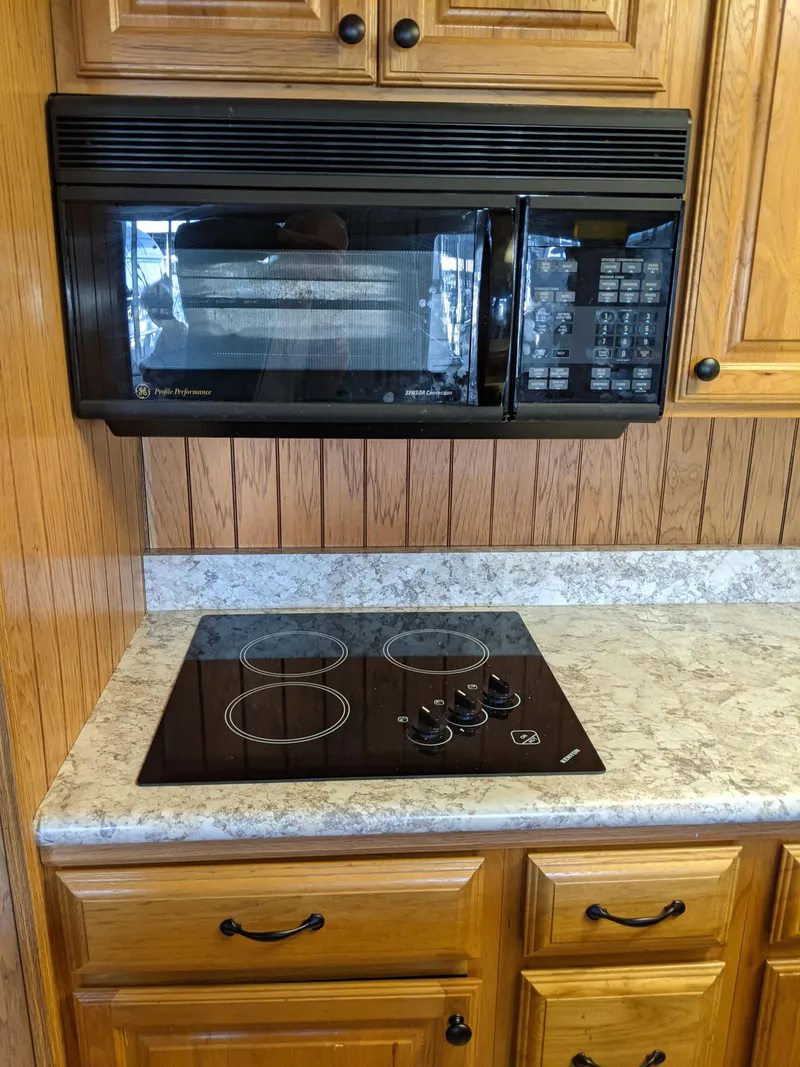 Slide: The Image of Kitchen area in a 2001 Monticello River Yacht with microwave and stovetop. - 17