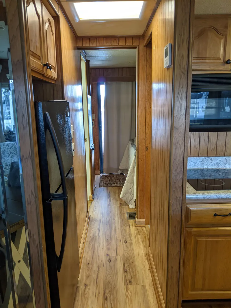 Slide: The Image of 2001 Monticello River Yacht interior hallway with wooden cabinetry and flooring. - 20