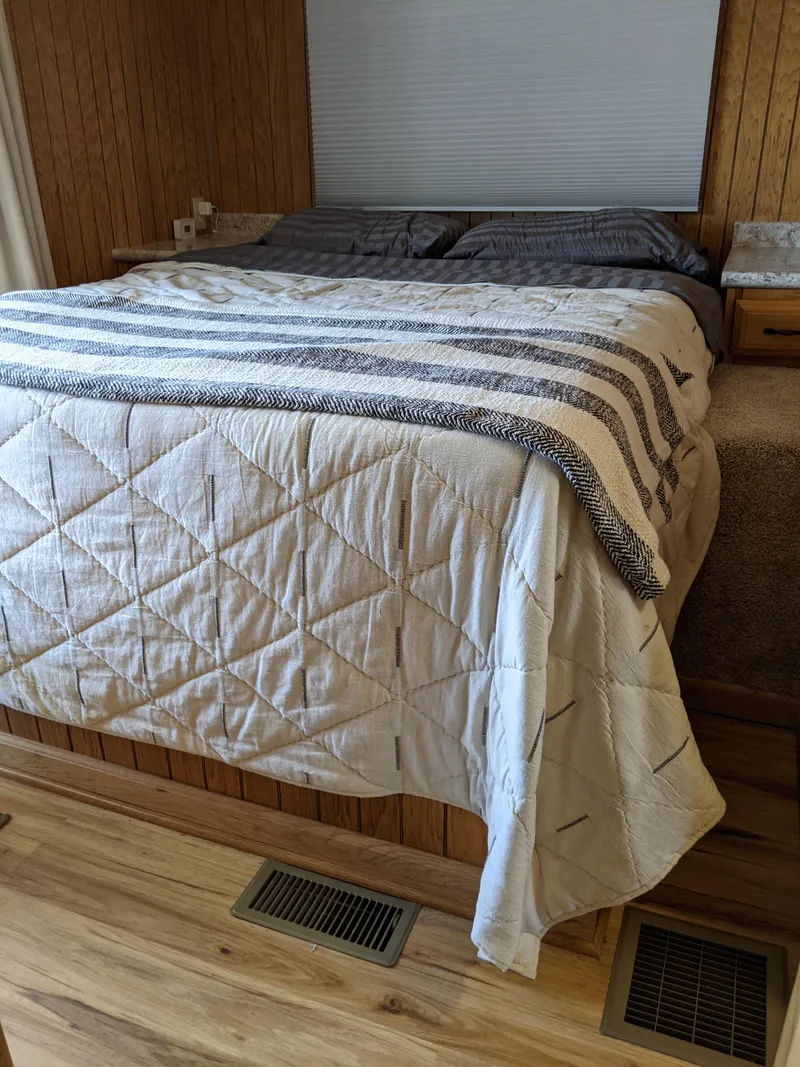 Slide: The Image of Cozy bedroom in a 2001 Monticello River Yacht with wooden paneling and a neatly made bed. - 21