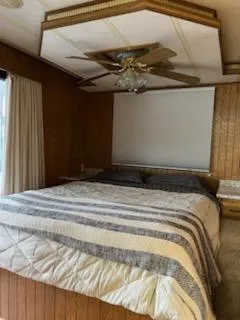 Slide: The Image of Cozy bedroom in 2001 Monticello River Yacht with wood paneling and ceiling fan. - 23