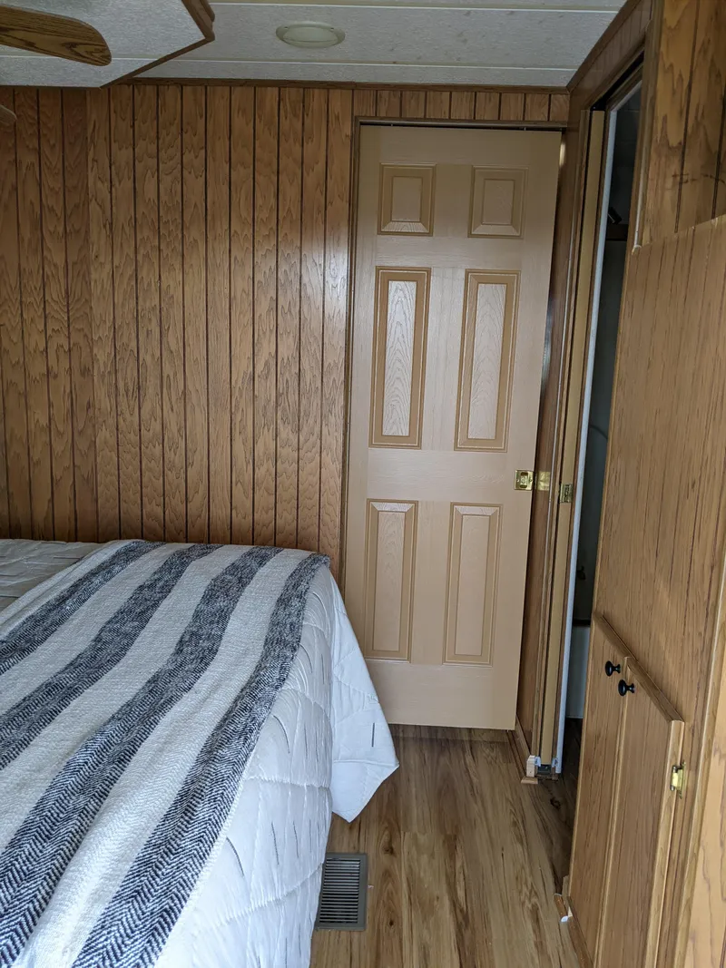 Slide: The Image of Interior cabin of a 2001 Monticello River Yacht with wood paneling and a bed. - 24