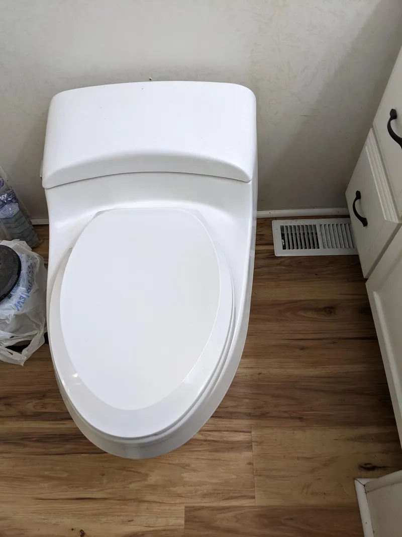 Slide: The Image of White toilet in a 2001 Monticello River Yacht bathroom with wooden flooring. - 28