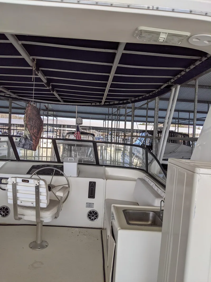 Slide: The Image of 2001 Monticello River Yacht interior with steering wheel, sink, and covered deck. - 40