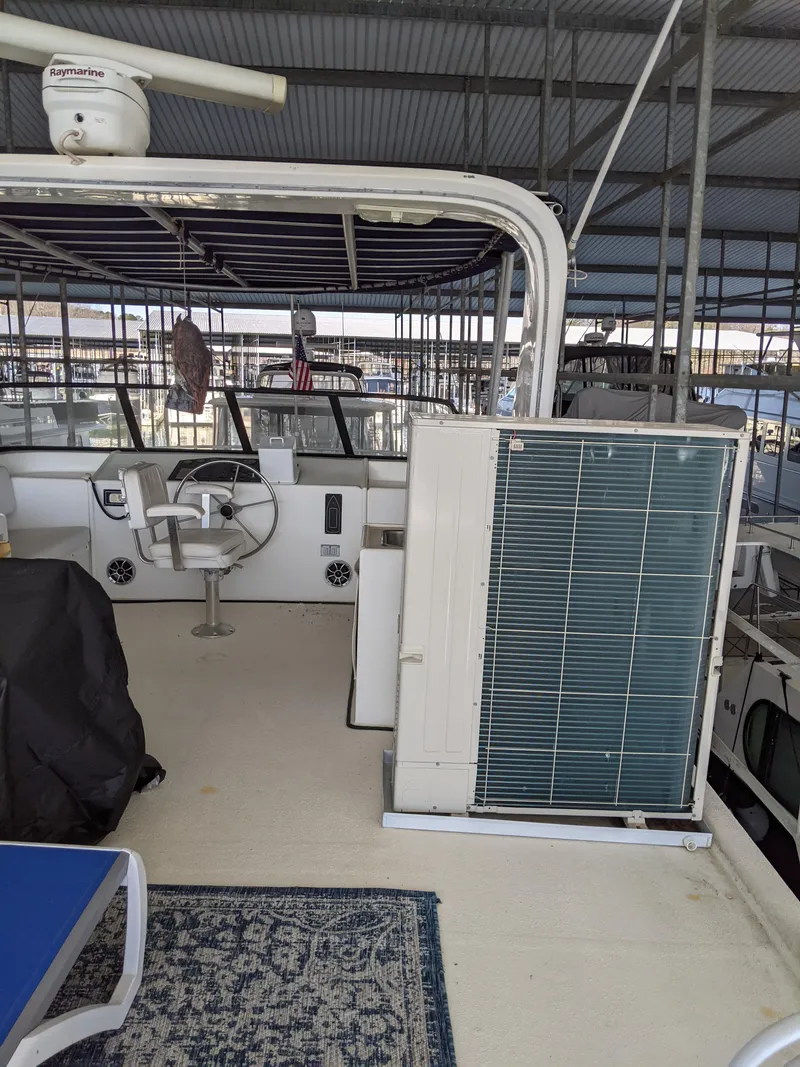 Slide: The Image of 2001 Monticello River Yacht interior with helm, seating, and air conditioning unit. - 42