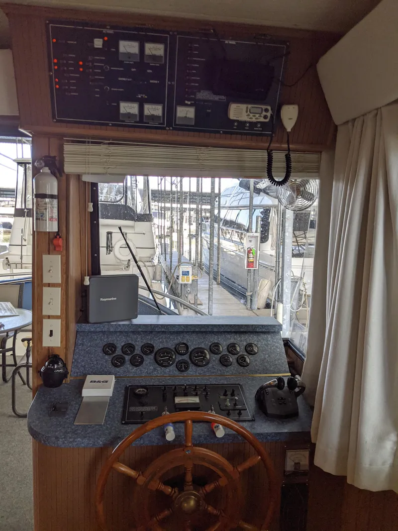 Slide: The Image of Control panel of a 2001 Monticello River Yacht with a wooden steering wheel. - 49