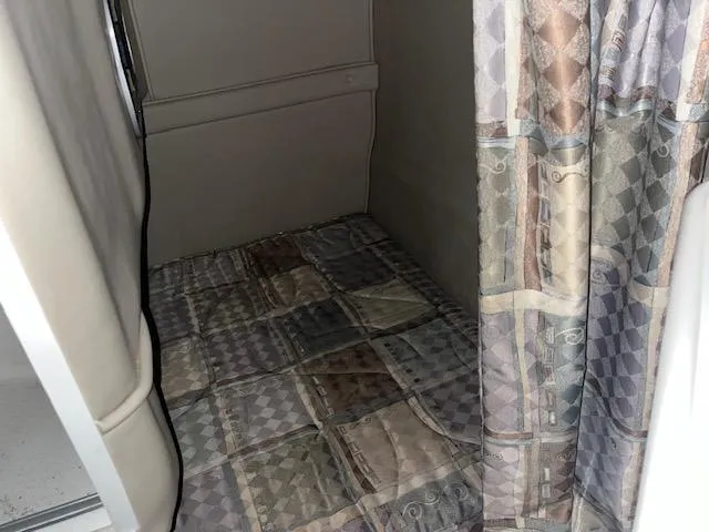 Slide: The Image of 2000 Chaparral 240 SIGNATURE cabin interior with patterned bedding and curtain. - 11