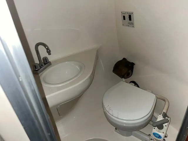 Slide: The Image of Compact bathroom in 2000 Chaparral 240 Signature boat with sink and toilet. - 12