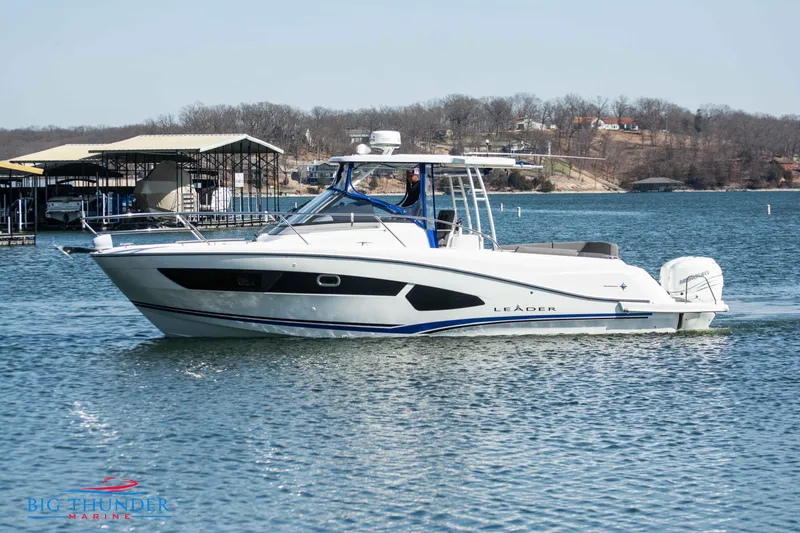The Image of 2020 Jeanneau Leader 10.5 boat cruising on a lake near a marina. - 0