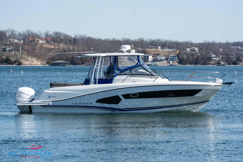 Slide: The Image of 2020 Jeanneau Leader 10.5 boat on a lake with houses in the background. - 14
