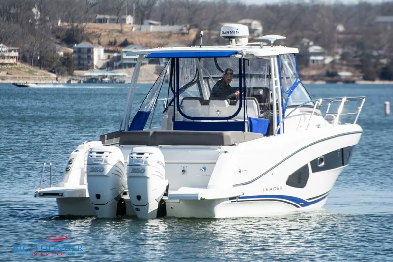 Slide: The Image of 2020 Jeanneau Leader 10.5 boat cruising on a lake with twin outboard engines. - 16