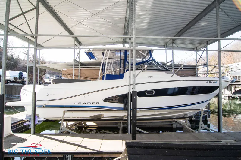 Slide: The Image of 2020 Jeanneau Leader 10.5 boat docked under a covered marina. - 19
