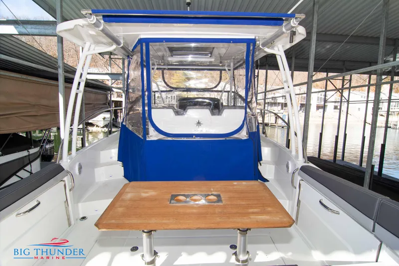 Slide: The Image of 2020 Jeanneau Leader 10.5 boat with blue canopy and wooden table in marina. - 31