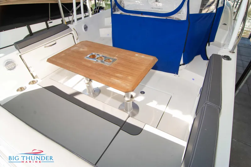 Slide: The Image of 2020 Jeanneau Leader 10.5 boat interior with seating and wooden table. - 32