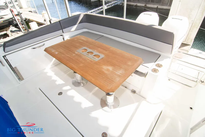 Slide: The Image of 2020 Jeanneau Leader 10.5 boat with a wooden table and cushioned seating area. - 34