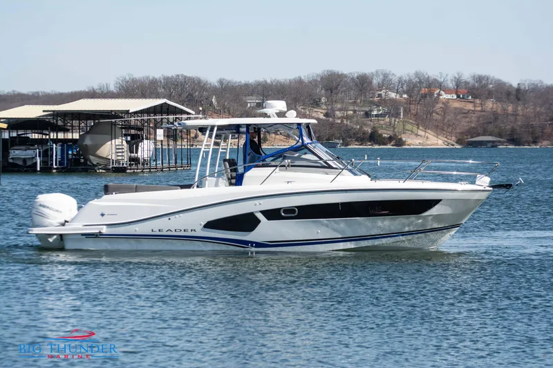 Slide: The Image of 2020 Jeanneau Leader 10.5 boat cruising on a lake near a marina. - 4