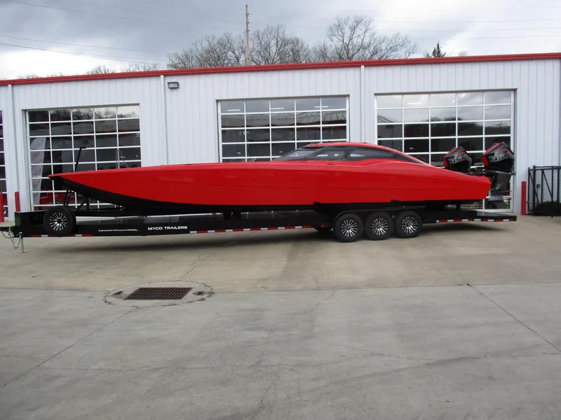 The Image of 2023 MTI 390XR red powerboat on a trailer outside a garage. - 1