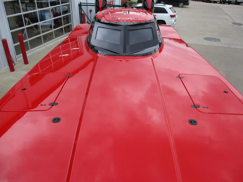 Slide: The Image of 2023 MTI 390XR red powerboat with sleek design, parked near a garage. - 14