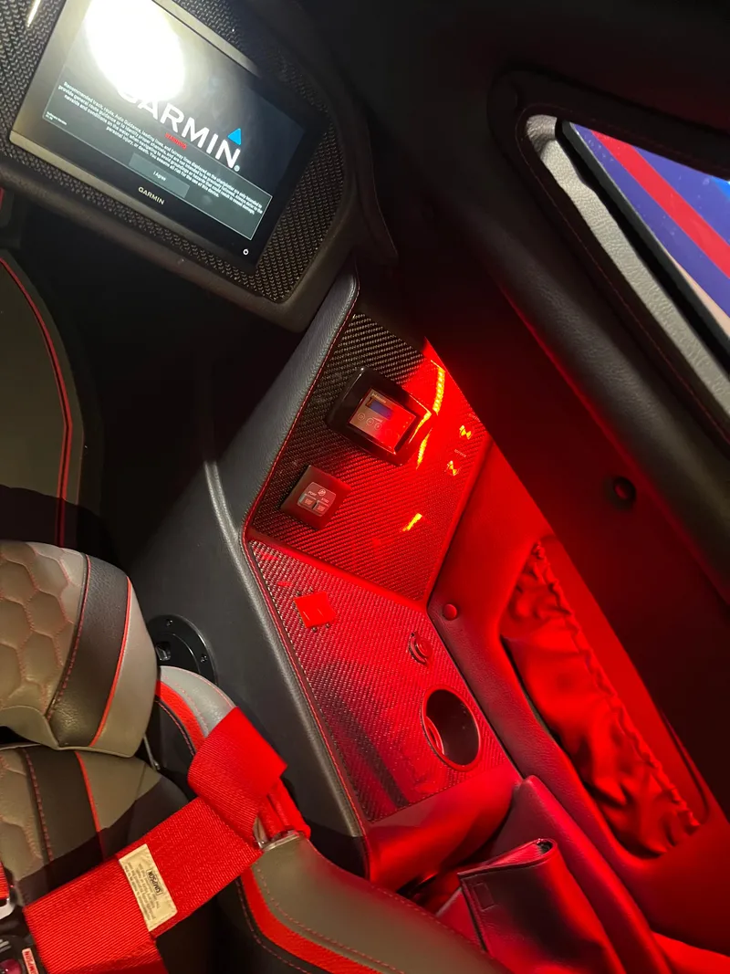Slide: The Image of Interior of 2023 MTI 390XR boat with red lighting and Garmin display. - 26
