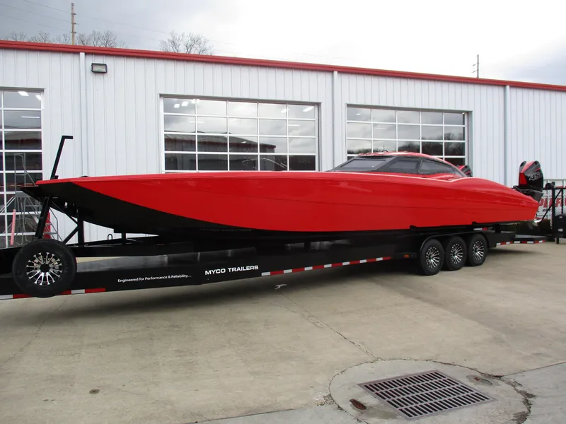 Slide: The Image of 2023 MTI 390XR powerboat on a trailer outside a garage. - 7