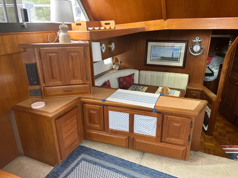 Slide: The Image of Interior of 1987 Viking Boats 44 Motor Yacht with wooden cabinetry and cozy dining area. - 13