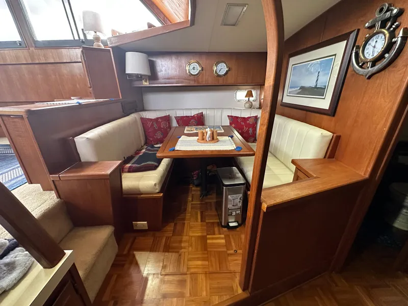 Slide: The Image of Cozy dining area in a 1987 Viking Boats 44 Motor Yacht with wood paneling and white seating. - 16