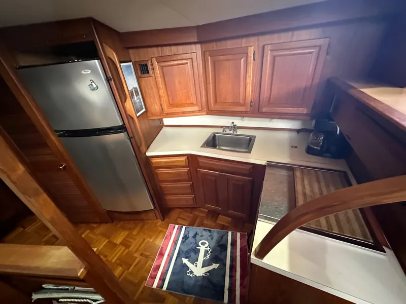 Slide: The Image of 1987 Viking Boats 44 Motor Yacht kitchen with wooden cabinets and stainless steel appliances. - 17