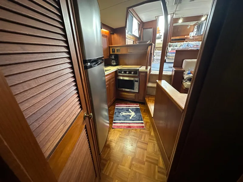 Slide: The Image of 1987 Viking Boats 44 Motor Yacht kitchen with stainless steel appliances and wooden cabinetry. - 24