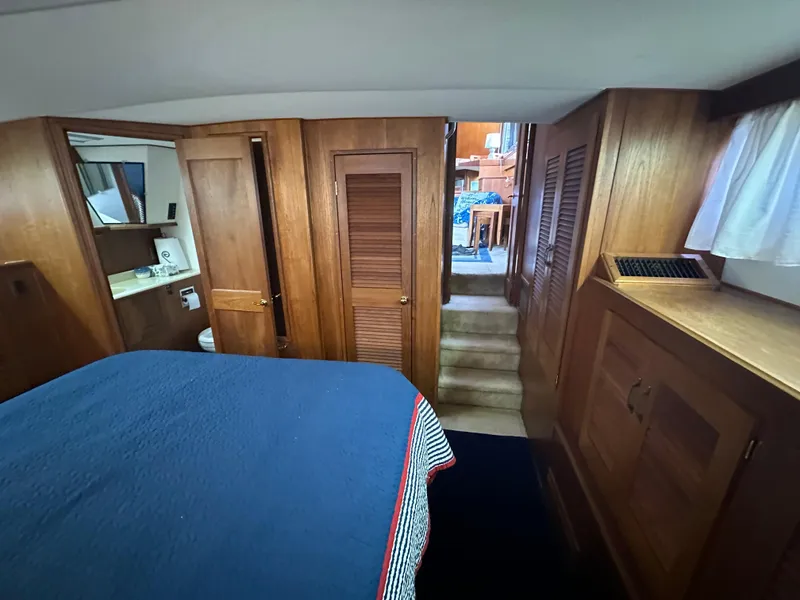 Slide: The Image of 1987 Viking Boats 44 Motor Yacht interior cabin with wooden cabinetry and blue bedding. - 32