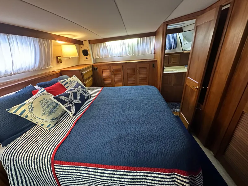Slide: The Image of 1987 Viking Boats 44 Motor Yacht bedroom with blue bedding and nautical decor. - 33
