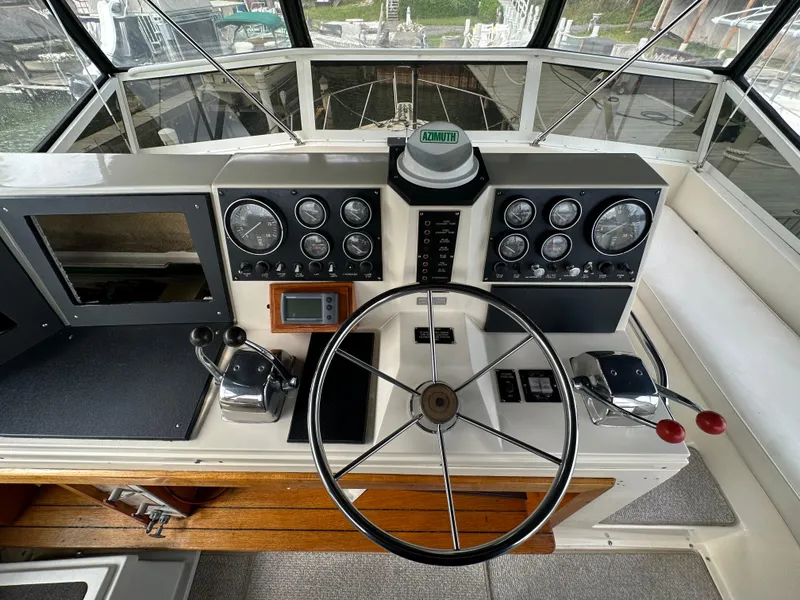 Slide: The Image of 1987 Viking Boats 44 Motor Yacht helm with steering wheel and control panel. - 46