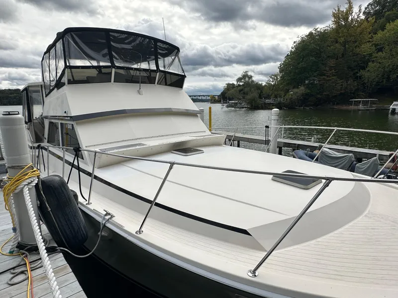 Slide: The Image of 1987 Viking Boats 44 Motor Yacht docked by a serene lake. - 8