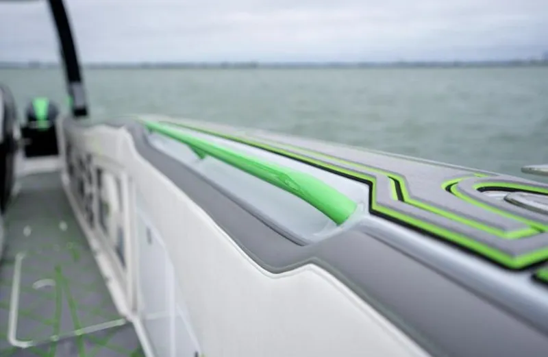 Slide: The Image of 2024 Deep Impact 399 Sport boat with green accent on water. - 11