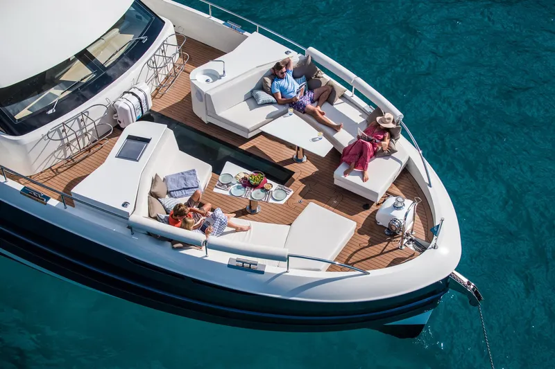 Slide: The Image of 2025 Van der Valk BeachClub 660 Flybridge yacht with people relaxing on deck. - 10