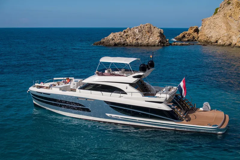 Slide: The Image of Van der Valk BeachClub 660 Flybridge 2025 yacht cruising near rocky coastline. - 5