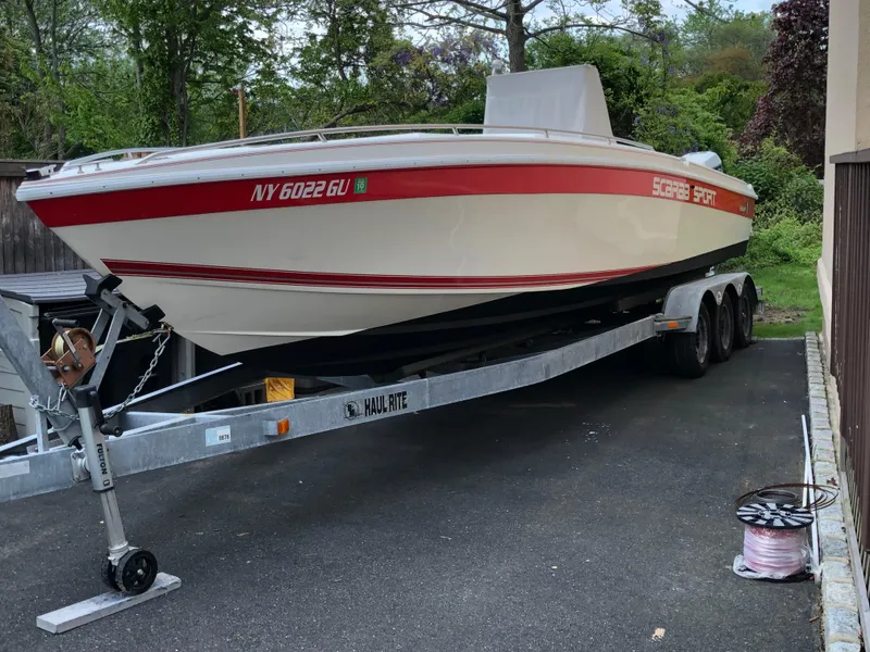 Slide: The Image of 1994 Wellcraft 302 SCARAB SPORT boat on trailer, parked outdoors. - 11