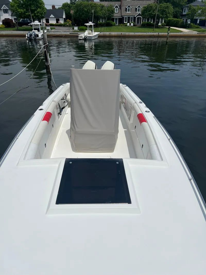 Slide: The Image of 1994 Wellcraft 302 Scarab Sport boat docked, featuring sleek white design and covered seating. - 2