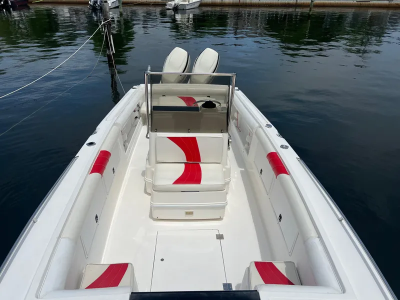 Slide: The Image of 1994 Wellcraft 302 Scarab Sport boat with red accents docked on calm water. - 3
