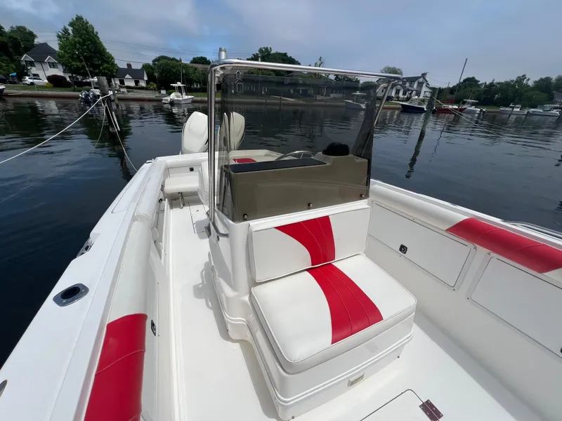 Slide: The Image of 1994 Wellcraft 302 Scarab Sport boat with red and white seating, docked by calm waters. - 4
