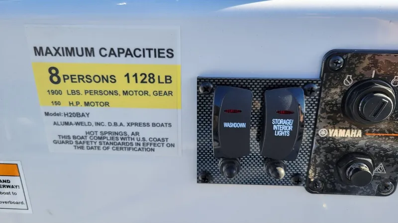 Slide: The Image of 2025 Xpress H20 Bay boat capacity label and Yamaha control panel, featuring washdown and storage lights. - 11