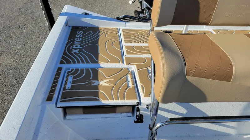 Slide: The Image of 2025 Xpress H20 Bay boat interior with tan seats and patterned flooring. - 19