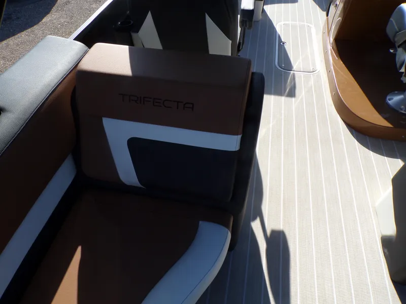 Slide: The Image of 2024 Trifecta 23 RF SS With Arch boat interior, featuring brown and white seating. - 26